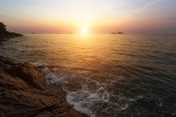 Sunset at rocky sea coast.