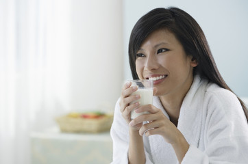 woman holding glass of milk, smiling