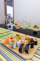 Wooden board with assorted sushi pieces