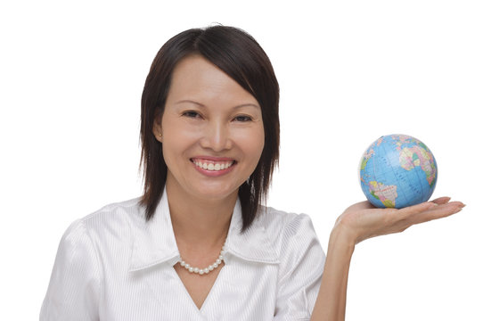 Woman holding globe and smiling at camera