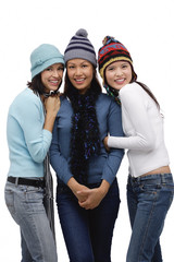 Three young women wearing scarves and hats, winter