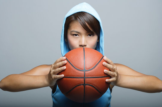 Young woman with basketball looking at camera