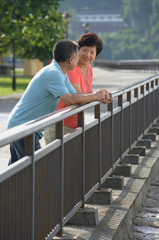 Couple having a conversation while leaning in fence