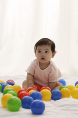 Fototapeta na wymiar Baby girl playing with balls