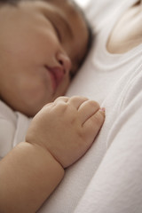 baby girl sleeping against woman's chest