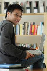 A young man studies in the library