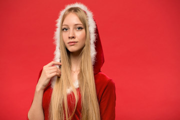 beautiful girl dressed in santa claus over a red background