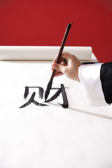 Woman writing Chinese calligraphy "Fortune"