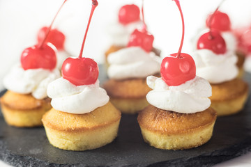 Cup cakes with cream and cherry