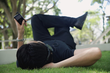 A man listens to music on a mp3 player in the park