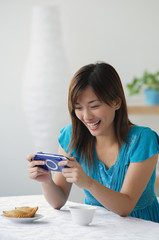 Young woman playing on handheld game console