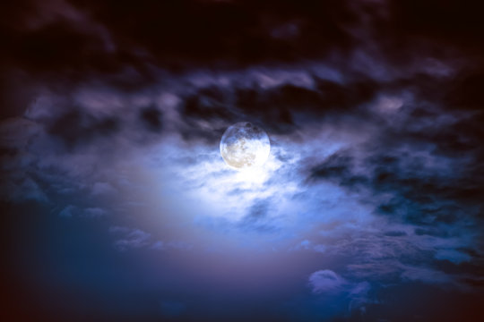 Nighttime sky with clouds and bright full moon with shiny.