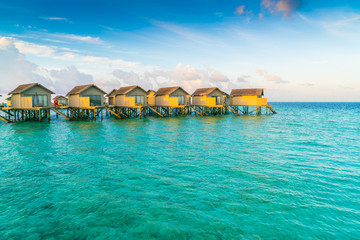 Beautiful water villas in tropical Maldives island at the sunris