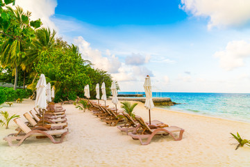 Beach chairs with umbrella at Maldives island, white sandy beach