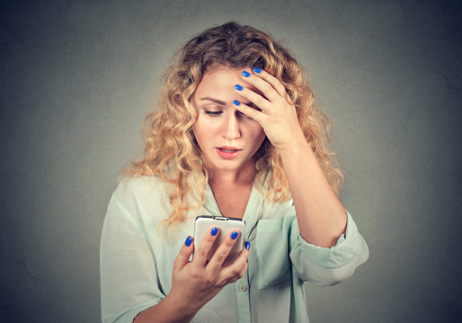 Upset woman holding cellphone disgusted with message she received