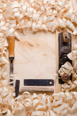 wood shavings on a wooden background with tools