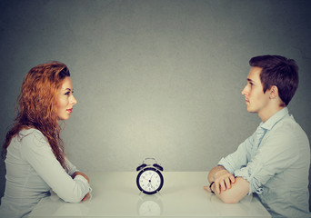 Speed dating. Man woman sitting across from each other at table - obrazy, fototapety, plakaty