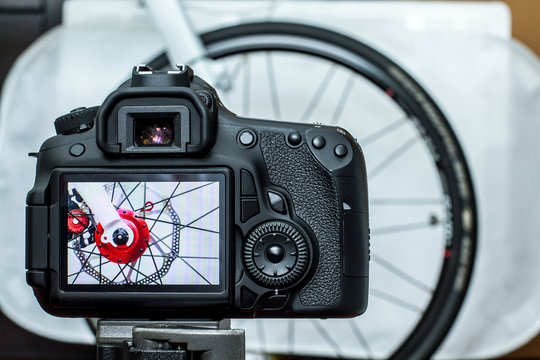 Live preview of a bike hub photo shooting, is displayed on a DSLR's LCD monitor. The bike hub in bright red is installed with disc brake, that removed off the forks with a quick release lever skewer.