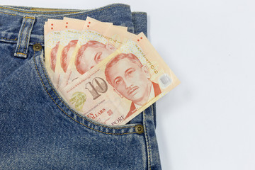 Close up Singapore dollars in a jeans pocket on white background