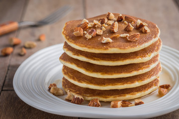 Pancakes with almonds and maple syrup on plate