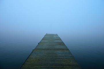Molo nad jeziorem w mgle.