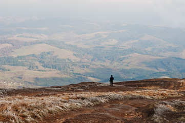 Man stand on hill and looking on moutains.