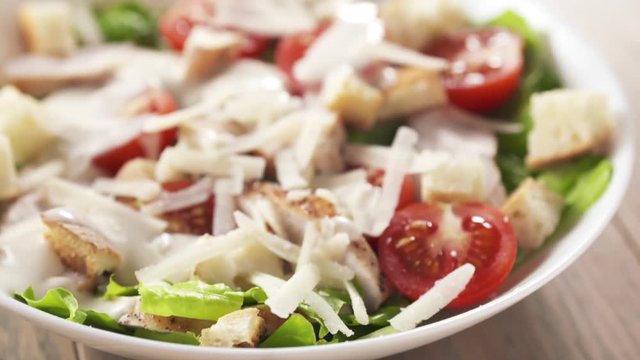 caesar salad closeup handheld pan over prepared dish
