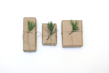Eco style gift wrapping. Three gift boxes decorated with pine branches. Top view, flat lay