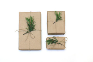 Eco style gift wrapping. Three gift boxes decorated with pine branches. Top view, flat lay
