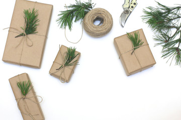 Fototapeta na wymiar Gifts packaging inspiration. Natural design. Kraft paper, jute cord, pine twigs and scissors.Top view, flat lay
