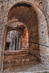 Fototapeta na wymiar Sorano, Grosseto, Tuscany, Italy: old narrow alley with dark underpass in the medieval town 