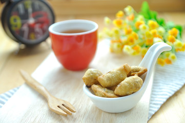 Thai crispy biscuit dessert with clock and flower on chopping bl