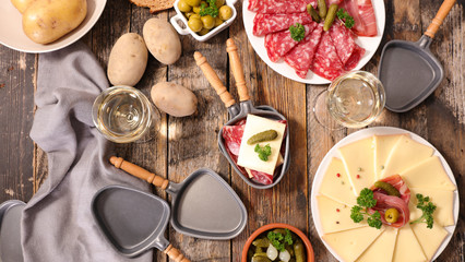 table with raclette cheese, meat and potato