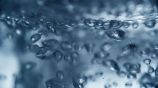 Close up of carbonated water producing gas bubbles as it being poured into glass