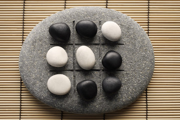 Fototapeta na wymiar black and white pebbles on zen stone