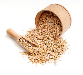 Oat flakes scattered from wooden bowl and scoop on white background. Top view, high resolution product