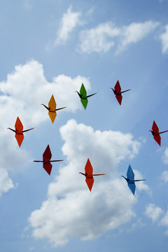 multiple paper cranes against sky backdrop