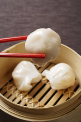 red chopsticks holding dimsum