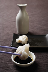 chopstick dipping dim sum in soy sauce