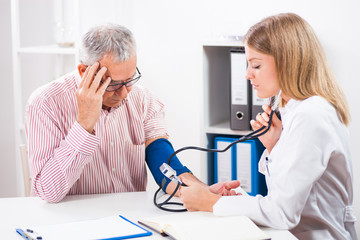 Doctor is measuring blood pressure to her patient.