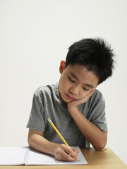 young boy working and writing