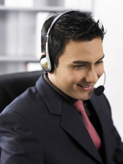 man listening to earphones and talking through microphone