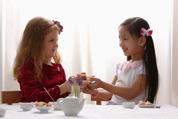 Obraz na płótnie Canvas two young girls having a tea party