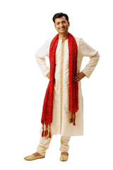 Indian man in traditional clothing, looking at camera, hands on hip