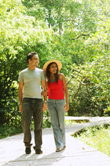 Naklejka na ściany i meble Man and woman walking side by side in park