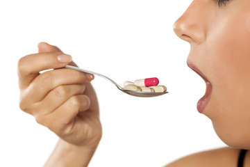 young woman eating from a spoon full of drugs