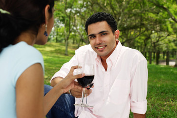 Couple toasting with wine glasses, man looking at camera