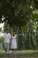 Fototapeta premium Singapore, Man and woman holding hands in park