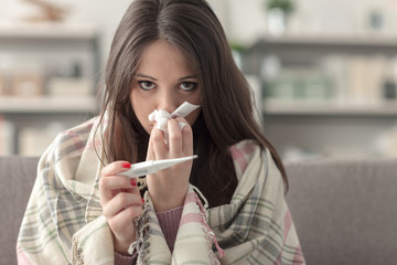 Sick woman taking temperature