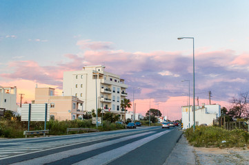 Fototapeta na wymiar Beautiful pink sunset with road and apartment building in Olhao, Portugal